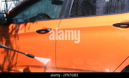 Autolavaggio manuale con acqua pressurizzata in autolavaggio esterno in estate. Foto Stock