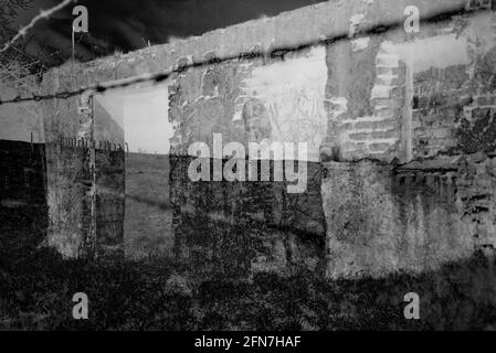 Scatto drammatico e moody di una parete grugnosa di An vecchio edificio in scala di grigi Foto Stock