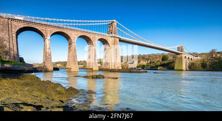 Vista panoramica del Ponte sospeso Menai, progettato da Thomas Telford e inaugurato nel 1826. Attraversa lo stretto di Menai vicino Bangor a Anglesey. Foto Stock