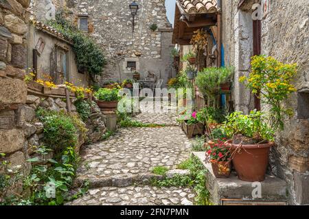 Vicolo chiuso con pavimentazione in pietra, case antiche e pareti in pietra a secco. Corvara, provincia di Pescara, Abruzzo, Italia, Europa Foto Stock