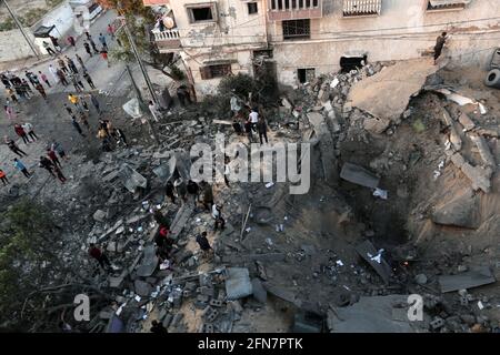 Gaza. 14 maggio 2021. I palestinesi ispezionano le macerie di una casa distrutta dagli attacchi aerei israeliani nella città di Khan Younis, nella striscia di Gaza meridionale, il 14 maggio 2021. Credit: Yasser Qudih/Xinhua/Alamy Live News Foto Stock