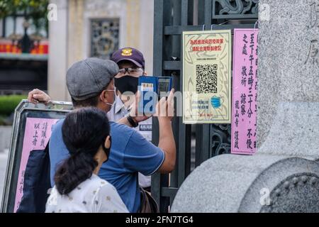 Taipei, Taiwan. 13 maggio 2021. Un uomo usa un codice di risposta rapida (QR) per accedere al tempio di Longshan a Taipei in mezzo a un'impennata di casi COVID19. Il Centro centrale di comando per le epidemie (CECC) di Taiwan ha riportato un totale di 180 nuovi casi COVID-19 e ha portato il livello di allarme al livello 3 a Taipei. Credit: SOPA Images Limited/Alamy Live News Foto Stock