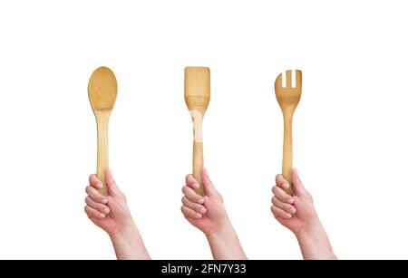 mano che tiene un cucchiaio di legno su fondo bianco isolato Foto Stock