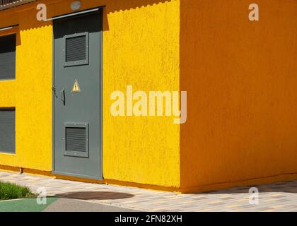 Nuovo trasformatore elettrico giallo moderno. Armadio del trasformatore. Scatola di comando elettrica esterna Foto Stock