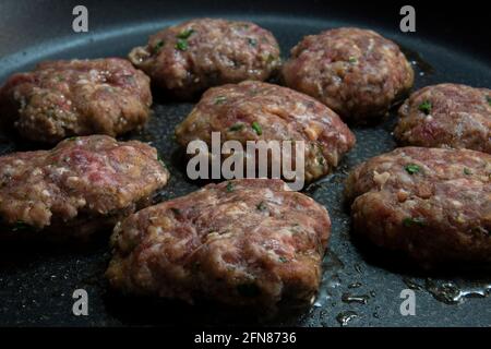 Le polpette fatte in casa vengono cucinate in una padella di ghisa. Polpette con messa a fuoco selettiva. Foto Stock