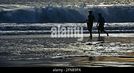 Tramonto con pescatori di lancia di fronte alle grandi onde sulla costa di la Jolla Cove a San Diego California meridionale USA. Foto Stock