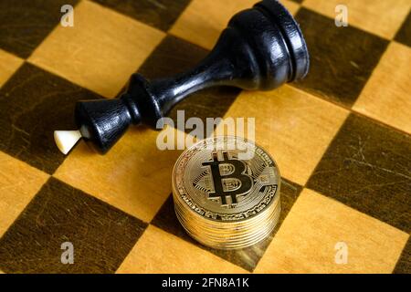 Scacchi re e bitcoin su scacchiera di legno, monete d'oro bit stack e game over. Concetto di strategia finanziaria, denaro virtuale, investimenti in criptovaluta Foto Stock