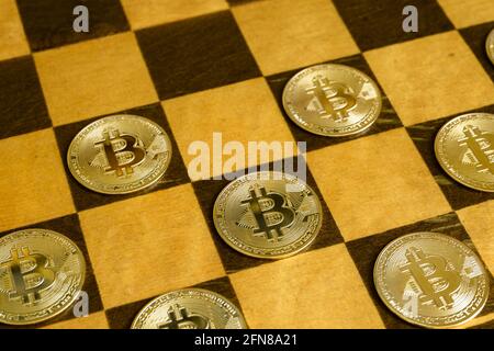 Dama o giochi di bozze con moneta di bit, vista di monete d'oro bit su tavola di legno. Concetto di strategia finanziaria, denaro digitale virtuale, criptovaluta i Foto Stock