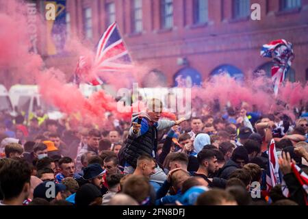 Glasgow, Scozia, Regno Unito. 15 maggio 2021. Migliaia di tifosi e tifosi della squadra di calcio dei Rangers scendono sull'Ibrox Park di Glasgow per celebrare la vittoria del campionato scozzese di premiership per la 55a volta e la prima volta per 10 anni. Le bombe di fumo e i fuochi d'artificio sono lasciati fuori dai ventilatori strettamente controllati dalla polizia lontano dalle entrate dello stadio.Iain Masterton/Alamy Live News Foto Stock