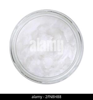 Olio di cocco in un vaso di vetro. Burro di cocco non raffinato, un olio commestibile, derivato dallo stoppino, dalla carne e dal latte della frutta di palma di cocco. Grasso solido bianco. Foto Stock
