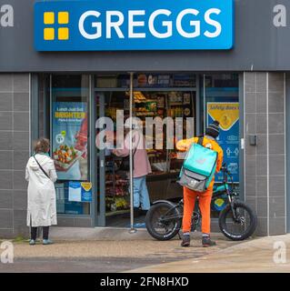 Preston, Lancashire UK: 15 maggio 2021. UK Business; il pranzo Greggs è appena diventato più luminoso a Preston con alcuni negozi di alimentari che offrono sconti speciali on-line. Basta mangiare i pranzi su ordinazione in una giornata fredda e umida nel centro di Preston, Regno Unito. Credito; MediaWorldImahes/AlamyLiveNews. Foto Stock