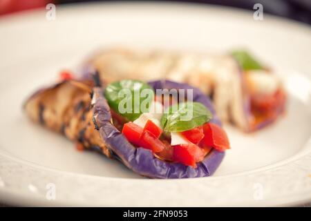 Melanzane al forno con formaggio parmigiano, pomodori e basilico Foto Stock