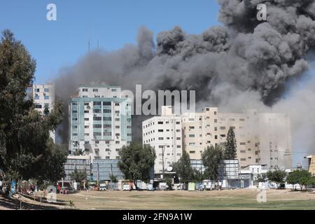 Gaza, Palestina. 15 maggio 2021. Un attacco aereo israeliano distrugge un alto edificio nella città di Gaza, nella striscia di Gaza, che ospitava i media outlet, tra cui la Associated Press e al Jazeera. Credit: SOPA Images Limited/Alamy Live News Foto Stock