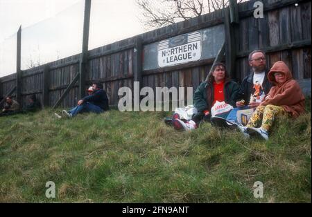 Una famiglia che si siede con un picnic mentre si guarda una partita di calcio non-campionato Foto Stock