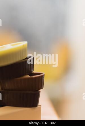 Quattro caramelle al cioccolato in scatola, primo piano di dolci al cioccolato, sfondo sfocato, messa a fuoco morbida, copia spazio di pasta Foto Stock