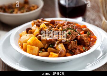 Stufato caldo con funghi e patate su un piatto. Foto Stock