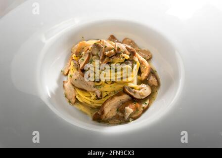 Tajarin con funghi porcini o Boletus edulis, fettuccine di Alba, Langhe, Piemonte, Italia, primo piano in piatto bianco Foto Stock