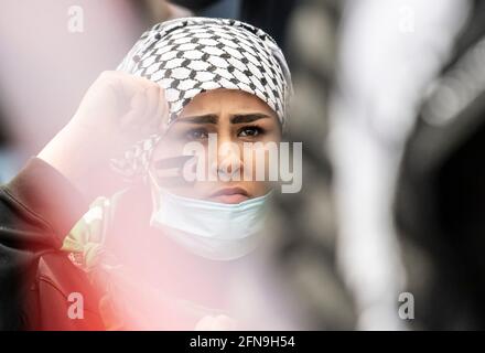 Francoforte, Germania. Maggio 15 2021: Numerose persone dimostrano alla Hauptwache di Francoforte, una donna ha dipinto la bandiera della Palestina sul suo volto. I partecipanti si sono riuniti nel centro della città, la polizia è sul posto con una forza massiccia. Le organizzazioni della "Palestina libera" vogliono richiamare l'attenzione sulla situazione attuale in Medio Oriente con la dimostrazione. Foto: Boris Roessler/dpa Foto Stock
