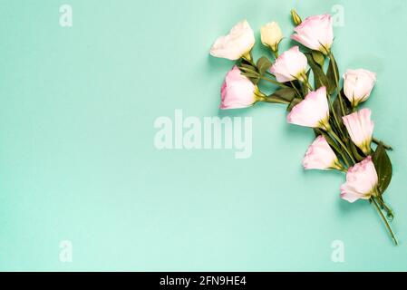 Composizione del telaio con spazio vuoto al centro costituito da eustoma rosa in fiore, giacitura piatta. Angoli decorativi floreali su sfondo verde. Foto Stock