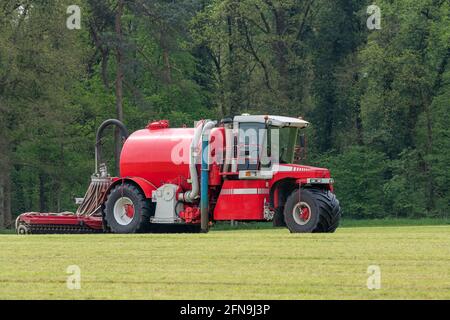 Iniezione di un prato appena falciato con un iniettore rosso in La primavera nei Paesi Bassi Foto Stock