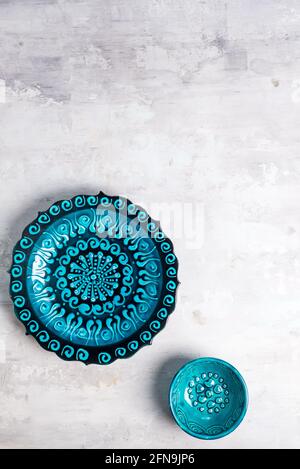 Ceramica turca decorata blu piatto e ciotola su fondo di pietra, vista dall'alto Foto Stock