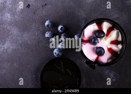 secchio di gelato colorato con frutti di bosco su fondo di pietra, piatto Foto Stock
