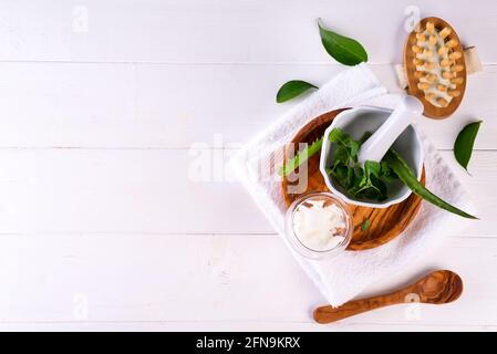 Concetto di trattamento spa con aloe vera, prodotti cosmetici naturali e spazzola massaggio su sfondo bianco in legno, spazio di copia piatto Foto Stock