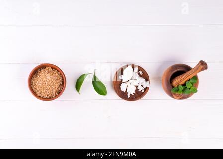 fondo spa con preparazione di prodotti cosmetici naturali fatti a mano su fondo bianco in legno, posa piatta Foto Stock