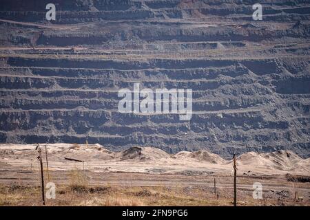 Vista di una parte di una cava di minerale di ferro con un treno ferroviario con terrazze per l'esportazione di minerale. Sfondo. Copiare lo spazio. Foto Stock