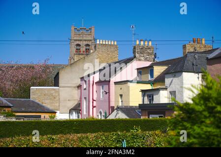 I lati posteriori di case multicolore a Coldstream High Street, Berwickshire, Scottish Borders, UK, con il Coldstream Community Center sullo sfondo. Foto Stock