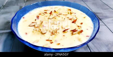 Coniglio dolce o Lachha Rabri o basundi, fatto con latte puro guarnito con frutta secca. Servito in una ciotola su sfondo di moody. Messa a fuoco selettiva Foto Stock