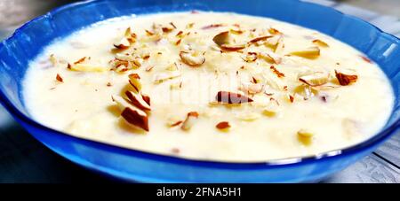 Coniglio dolce o Lachha Rabri o basundi, fatto con latte puro guarnito con frutta secca. Servito in una ciotola su sfondo di moody. Messa a fuoco selettiva Foto Stock