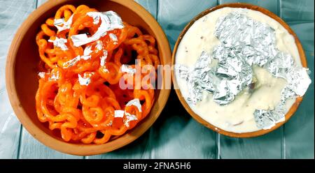 Kesari Jalebi/Jilbi con Rabbdi è una deliziosa ricetta indiana servita Come un Dessert in festival o matrimoni.fuoco selettivo Foto Stock