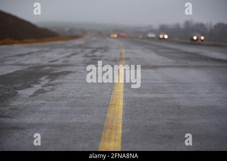 Strada bagnata in costruzione dopo la pioggia. Foto Stock