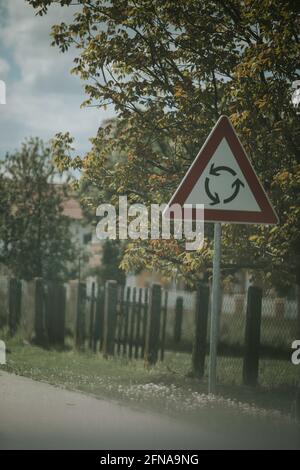 Immagine verticale di una rotonda triangolare su una strada Foto Stock