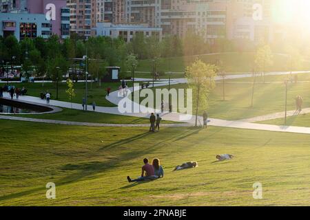 Russia, Mosca - 15 maggio 2021: Campo di Khodynka, Parco e zona residenziale. Le persone si rilassano nel parco cittadino al tramonto in una giornata calda. Foto di alta qualità Foto Stock