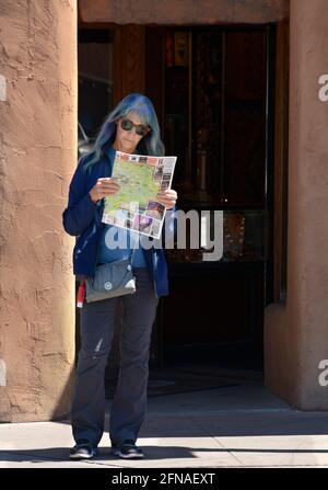 Una donna in visita a Santa Fe, New Mexico, consulta una mappa di strade e attrazioni distribuita ai turisti. Foto Stock