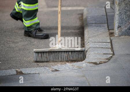 Bucarest, Romania - 15 aprile 2021: Un lavoratore di janitor spazza la spazzatura da una pista ciclabile a Bucarest. Foto Stock