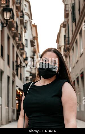 Bellissima ragazza che guarda la macchina fotografica su una strada ben illuminata Foto Stock