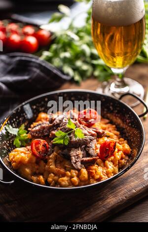 Gnocchi italiani in salsa di pomodoro, serviti con carne di manzo di razza e conditi con prezzemolo fresco. Foto Stock