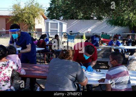 Laredo, Stati Uniti. 15 maggio 2021. Operatori sanitari che registrano i migranti per il test di Covid 19 in una clinica all'aperto presso il rifugio.Holding Community Service fornisce rifugio, cibo e test di Covid 19 all'arrivo delle famiglie migranti al centro. Secondo stime non ufficiali, circa 200,000 migranti sono passati negli Stati Uniti lungo il confine meridionale dal febbraio 2021. (Foto di J Lamparski/SOPA Images/Sipa USA) Credit: Sipa USA/Alamy Live News Foto Stock