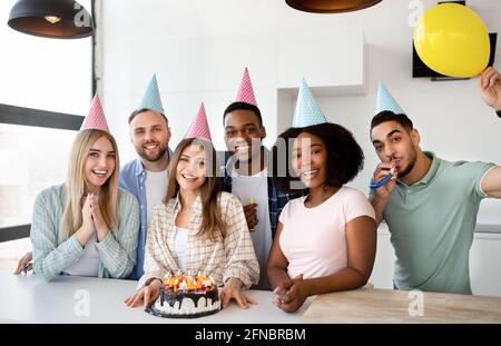 Ritratto di diversi giovani amici che festeggiano il compleanno insieme a casa Foto Stock