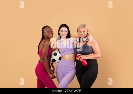 Sport per ogni corpo. Allegre femmine multietniche in Sportswear che posano insieme Foto Stock