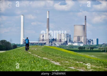 Rafahrer auf dem Rheindamm bei Rheinberg-Orsoy vor Industrie- und Naturkulisse. Foto Stock