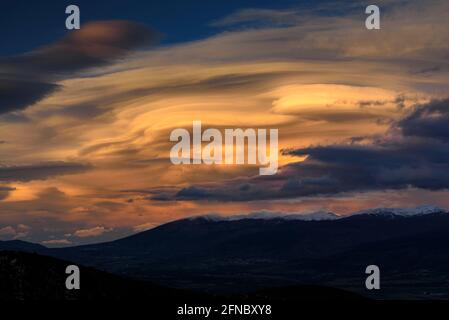 Tramonto di primavera a la Cerdanya, visto da vicino Ordèn, con le nuvole lenticolari su Puigmal - Cambredase (Lleida, Catalogna, Spagna, Pirenei) Foto Stock