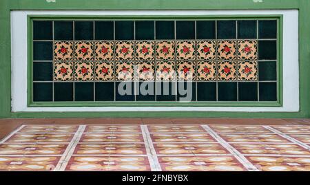 Mosaico in piastrelle peranakan in ceramica decorativa sulla facciata di un negozio tradizionale cinese. Foto Stock