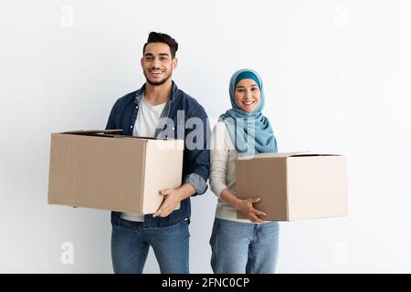 Sorridente coppia musulmana che si sposta in un nuovo appartamento Foto Stock