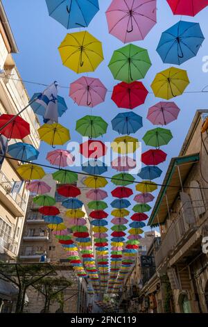 Gerusalemme, Israele - 29 aprile 2021:colorati ombrelli decorativi appesi su una strada di Gerusalemme. Foto Stock