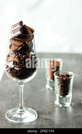 Bicchiere di vino riempito con diversi tipi di cioccolatini; dolce desiderio; spuntino al cioccolato Foto Stock