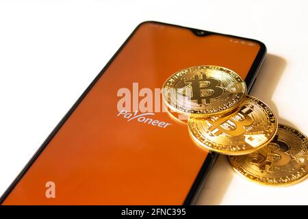 BIELORUSSIA, NOVOPOLOTSK -16 MAGGIO 2021: App e bitcoins per il telefono payoneer da vicino Foto Stock